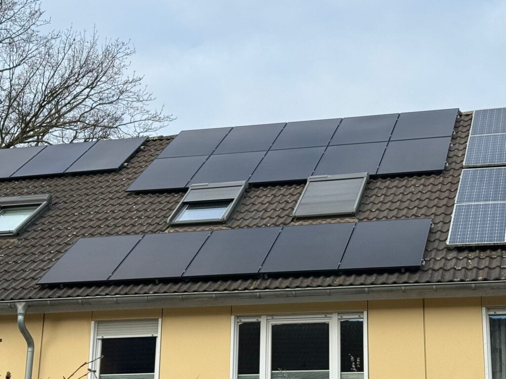 Moderne Solarmodule auf einem Hausdach, die nachhaltige Energie für den Haushalt erzeugen.
