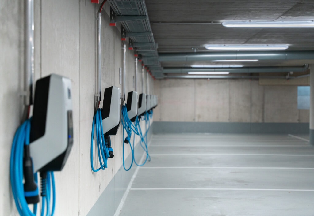Wallbox Prüfung in einer Garage mit Ladesäulen und Verbindungskabeln.